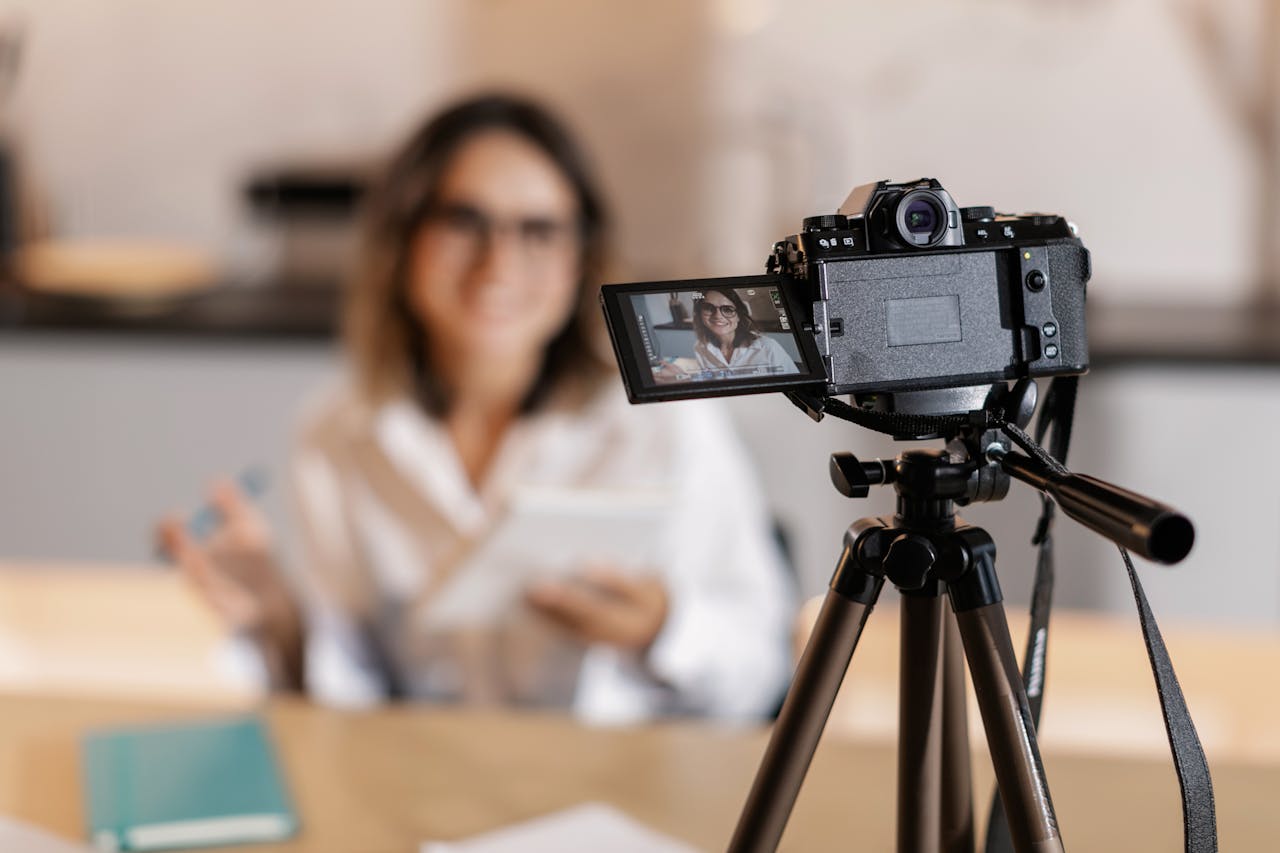 services-04 Woman vlogger using a camera and tripod for content creation indoors.